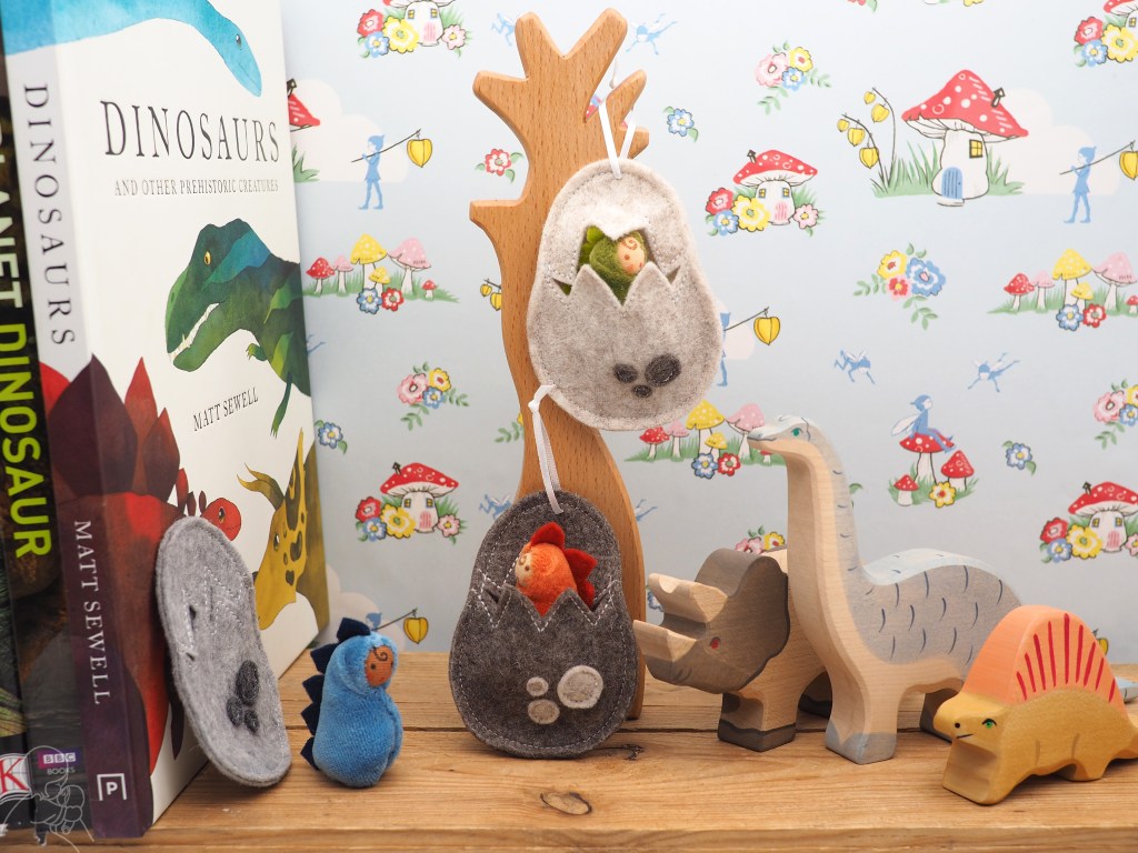 Three baby dinosaurs on a shelf